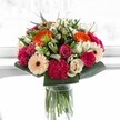 This bouquet, bursting with vivid colour and emotion, feels like a celebration of Catford life-a festive moment delicately preserved in blooms. At first glance, spirited orange gerberas spread warmth and cheer, recalling sunlit mornings by Catford Bridge. They mingle effortlessly with blush-pink roses and luxuriously textured magenta carnations, creating layers of softness and vibrancy. Creamy ivory roses and peach gerberas lend a subtle, elegant harmony, balancing the palette and infusing the arrangement with tender affection. Glossy green leaves envelop the bouquet, cradling each flower in a lush embrace and echoing the abundant greenery of nearby parks. Bathing in bright, almost ethereal light, every petal is gently illuminated, revealing fine veining and depth-each colour dances, animated by the sunlit atmosphere. This joyful creation feels both uplifting and heartfelt, making it perfectly suited for milestone moments, birthdays, or simply to send happiness to someone special in Catford. Artfully arranged by local hands, this bouquet is a testament to community, connection, and the simple beauty of flowers delivered with care across SE6.