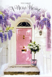 The photograph presents a lovingly styled doorway that feels unmistakably like the start of a new story somewhere off the leafy streets of Catford. The focal point is a gentle, pastel pink front door, its surface velvety and matte, catching soft light that could easily be the afternoon sun slipping between townhouses near Mountsfield Park. Encircling the doorframe, wisteria drapes down in generous curtains, each strand lined with tiny, bell-like blooms in shades of lavender and lilac. These flowering tendrils frame the scene with a natural, romantic arch, contrasting with the crisp whitewashed walls and a pale shutter painted to echo the door's blush tone. At ground level, resting neatly on the step, sits a chic tin bucket in soft grey, a touch of rustic charm at this otherwise polished entrance. It overflows with white and cream roses, their petals thick, full, and slightly curled at the edges, suggesting they're at their most fragrant. Sprays of cool green foliage weave among the roses, adding texture and life, while a soft pink ribbon is tied around the base, its bow poised like a subtle signature. The colour palette of blush pinks, creamy whites, and fresh greens creates a mood of optimism and tenderness, much like arriving with a housewarming bouquet to a friend's new place near Catford Bridge or by the quieter roads towards Bellingham. The overall feeling is one of gentle celebration: a scene that quietly says welcome home, well done, and this is where your next chapter begins all at once.
