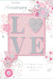 This anniversary card offers a gentle celebration of enduring romance, much like a soft-spoken I love you shared on a quiet evening in Catford. The design blends pastel pinks, silvery greys, and pearly whites into a calm, intimate palette that feels both modern and timeless. At the centre, the word LOVE is beautifully raised from the card's surface, its letters coated in fine, soft glitter that shimmers without overwhelming the eye. The letter O is replaced by a shimmering heart, textured in silver so that fingertips can feel its outline, echoing the way you might trace the edge of a delicate petal. Around this focal word, an array of delicate blooms in blush and mauve unfolds with a watercolour softness, their edges gently blurred and their centres touched with subtle silver highlights. Fine, flowing lines suggest curling stems and vines, while tiny flourishes of petals, spirals, and discreet butterflies add a sense of movement, as if a light breeze were drifting across a spring garden near Ladywell or Bellingham. The soft pink background acts like a warm embrace, pulling the floral details together into a cohesive, harmonious composition. Scripted text reading On Our Anniversary and I love you today and always appears in an elegant, understated style, its curves echoing the natural shapes of the surrounding leaves and tendrils. Though this is a single flat card, the layered effect of embossing, glitter, and intricate illustration gives it a richness similar to an artfully composed bouquet, making it an ideal keepsake for marking a shared journey of love in Catford and the wider SE6 community.